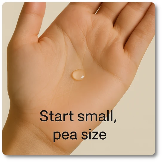 pea-size-moroccan-oil-application-tip A close-up photograph of a left human hand with a small, pea-sized drop of hair oil resting in the center of the palm. The skin is warm-toned and well-lit, set against a neutral beige background. Overlay text at the bottom reads, “Start small, pea size” in a clean, black font.